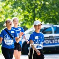 Three Alumni walking and smiling.